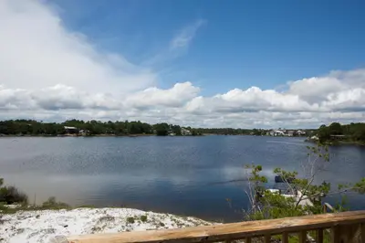 a view of a large lake with a wooden fence at All's Well in Santa Rosa Beach