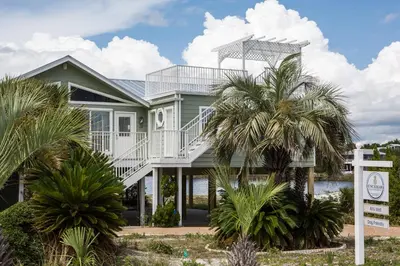 a house with palm trees in front of it at All's Well in Santa Rosa Beach