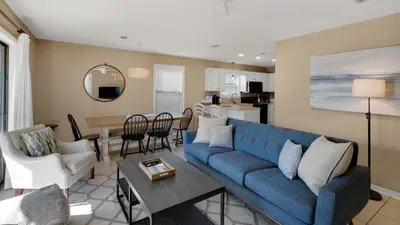 a living room with a blue couch and a table at Beachwood Villas 14B - Simply Seagrove in Santa Rosa Beach