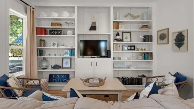 a living room with a couch and a tv at Sublime in Seagrove Beach