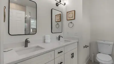 a bathroom with a sink and a toilet and a mirror at Sublime in Seagrove Beach