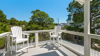 two white chairs sitting on a balcony at Sublime in Seagrove Beach