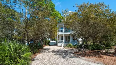 a white house with trees in front of it at Sublime in Seagrove Beach