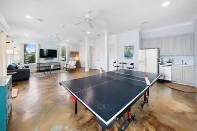 a ping pong table in the middle of a living room at The Retreat in Santa Rosa Beach