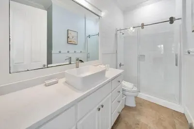 a white bathroom with a sink and a toilet at The Retreat in Santa Rosa Beach