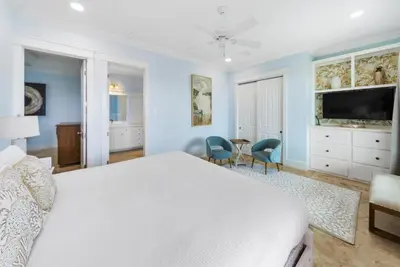 a bedroom with a bed and a table and chairs at The Retreat in Santa Rosa Beach