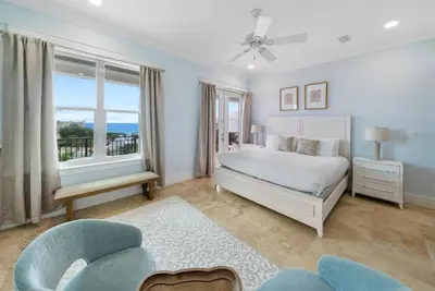 a white bedroom with a bed and a window at The Retreat in Santa Rosa Beach