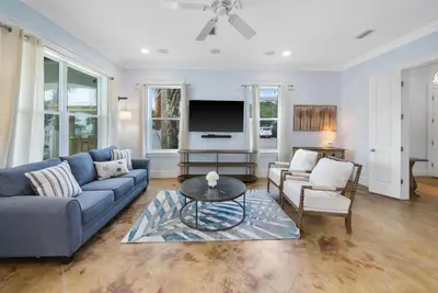 a living room with a blue couch and a tv at The Retreat in Santa Rosa Beach