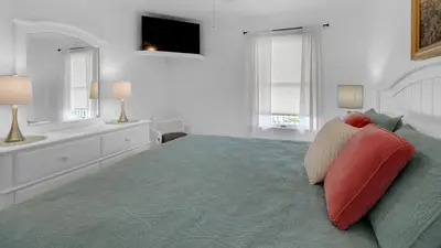 a bedroom with a large bed with red pillows at Mistral 11 in Seacrest