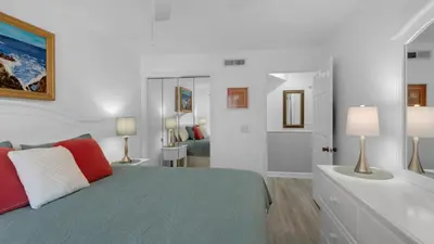 a white bedroom with a bed and a bathroom at Mistral 11 in Seacrest