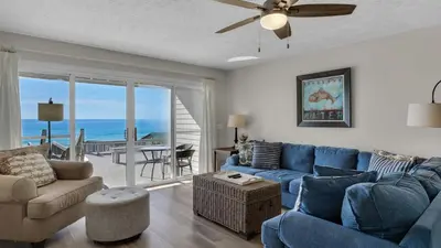 a living room with a blue couch and chairs and a balcony at Blue Nine 5 in Panama City Beach