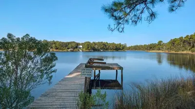 a dock on a lake with a sign on it at Heron's Watch 5101 in Santa Rosa Beach