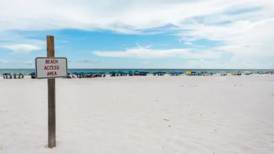 a sign on a beach with people in the background at Heron's Watch 5101 in Santa Rosa Beach