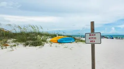 a sign on a beach with a boat in the sand at Heron's Watch 5101 in Santa Rosa Beach