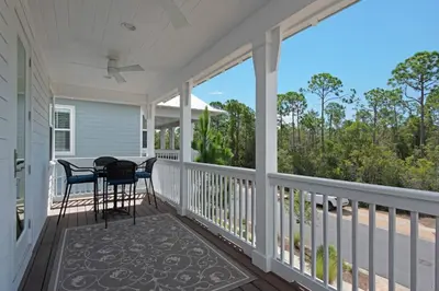 a screened in porch with a table and chairs on it at 9 Prairie Pass in Santa Rosa Beach