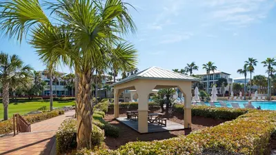 a gazebo next to a pool with a palm tree at Our Blue Haven in Inlet Beach