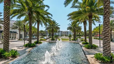 a fountain in a park with palm trees at Our Blue Haven in Inlet Beach