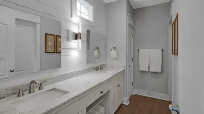 a white bathroom with two sinks and a window at Villas at Seagrove A202 - Sandcastles at Seagrove in Santa Rosa Beach