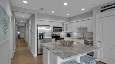 a kitchen with white cabinets and a marble counter top at Villas at Seagrove A202 - Sandcastles at Seagrove in Santa Rosa Beach