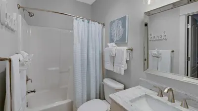 a white bathroom with a toilet and a sink at Villas at Seagrove A202 - Sandcastles at Seagrove in Santa Rosa Beach