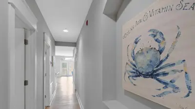 a hallway with a painting of a spider on the wall at Villas at Seagrove A202 - Sandcastles at Seagrove in Santa Rosa Beach
