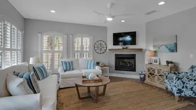 a living room with white furniture and a fireplace at Villas at Seagrove A202 - Sandcastles at Seagrove in Santa Rosa Beach