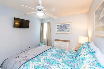 a bedroom with a bed and a ceiling fan at Beachwood Villas #9E - Sandy Cheeks in Santa Rosa Beach