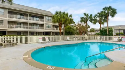 a swimming pool in front of a building with palm trees at Beachwood Villas #9E - Sandy Cheeks in Santa Rosa Beach