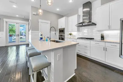 a kitchen with white cabinets and a large island at Bluegrass by the Sea in Santa Rosa Beach