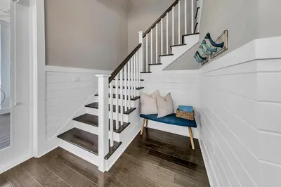 a white staircase with a blue chair in a room at Bluegrass by the Sea in Santa Rosa Beach