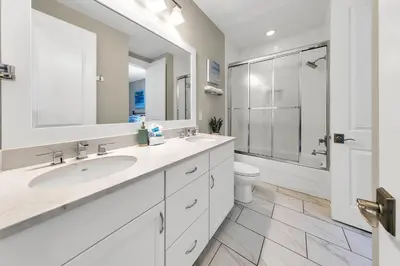 a white bathroom with two sinks and a toilet at Bluegrass by the Sea in Santa Rosa Beach