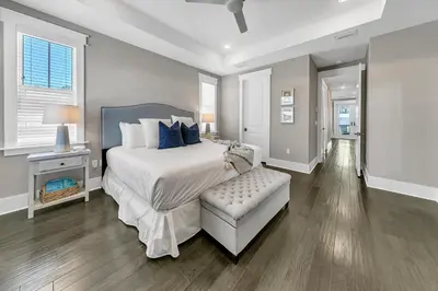 a bedroom with a bed and a bench in it at Bluegrass by the Sea in Santa Rosa Beach