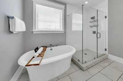 a white bathroom with a tub and a glass shower at Bluegrass by the Sea in Santa Rosa Beach