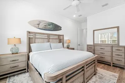 a bedroom with a large bed and a mirror at 30A Beach House - Mira Bella in Rosemary Beach