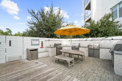 a patio with a table and an umbrella at The Pointe on 30A by Panhandle Getaways in Rosemary Beach