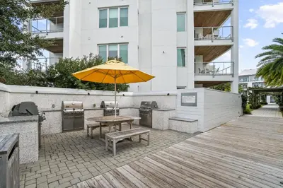 a patio with a table and an umbrella at The Pointe on 30A by Panhandle Getaways in Rosemary Beach