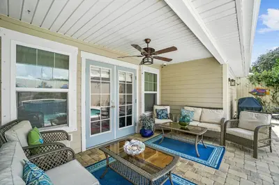 a screened in porch with a ceiling fan at Pet Friendly Beach House - Paradise on Palm by Panhandle Getaways in Panama City Beach