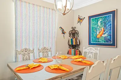 a dining room with a table with orange dishes on it at Pet Friendly Beach House - Paradise on Palm by Panhandle Getaways in Panama City Beach