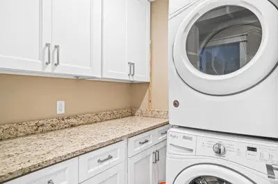 a white laundry room with a washer and dryer at Pet Friendly Beach House - Paradise on Palm by Panhandle Getaways in Panama City Beach