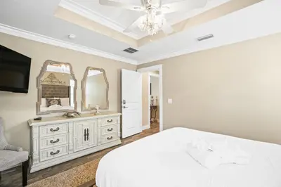 a bedroom with a white bed and a mirror at Pet Friendly Beach House - Paradise on Palm by Panhandle Getaways in Panama City Beach
