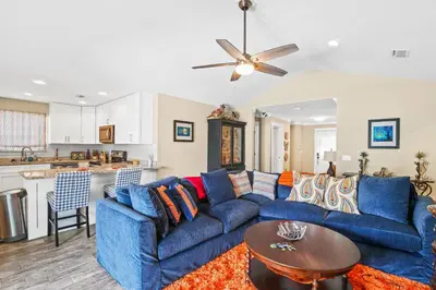 a living room with a blue couch and a table at Pet Friendly Beach House - Paradise on Palm by Panhandle Getaways in Panama City Beach