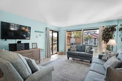 a living room with two couches and a flat screen tv at Edgewater Golf Villa 2110 in Panama City Beach
