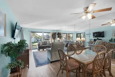 a dining room and living room with a table and chairs at Edgewater Golf Villa 2110 in Panama City Beach