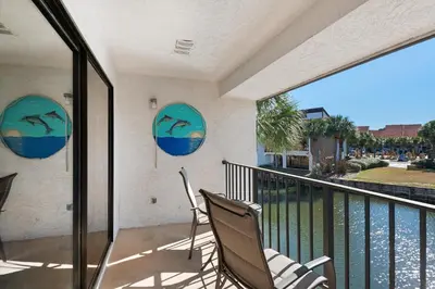two chairs on a balcony with a view of the water at Edgewater Golf Villa 2110 in Panama City Beach