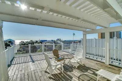 a patio with chairs and a table on a deck at Amzg Gulf view,4 Bd/3.5 Bath Home, Pvt heated Pool in Panama City Beach
