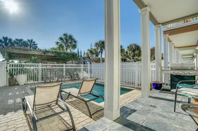 a patio with two chairs and a swimming pool at Amzg Gulf view,4 Bd/3.5 Bath Home, Pvt heated Pool in Panama City Beach