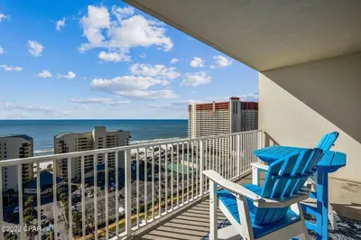 a blue chair sitting on a balcony overlooking the ocean at Beautiful Condo with Ocean View from 15th Floor in Panama City Beach