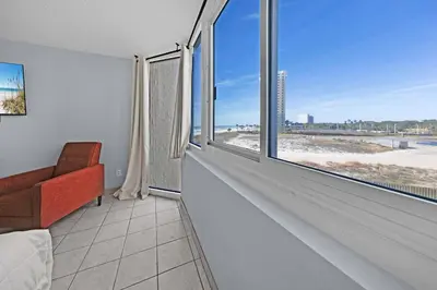 a room with a large window with a view of the beach at Top of the Gulf 416 in Panama City Beach