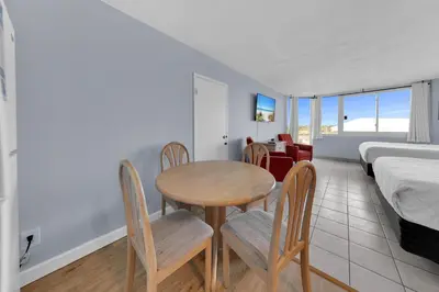 a room with a table and chairs and a bed at Top of the Gulf 416 in Panama City Beach