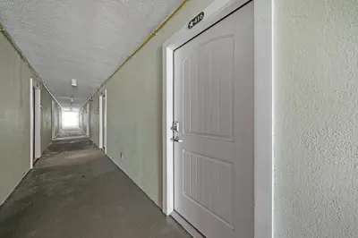 a corridor with a white door in a hallway at Top of the Gulf 416 in Panama City Beach